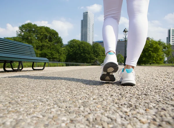 Kvinnan promenader i stadsparken — Stockfoto