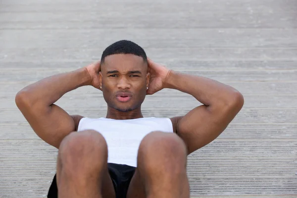 Genç adam yaparken egzersiz dışında ups sit — Stok fotoğraf