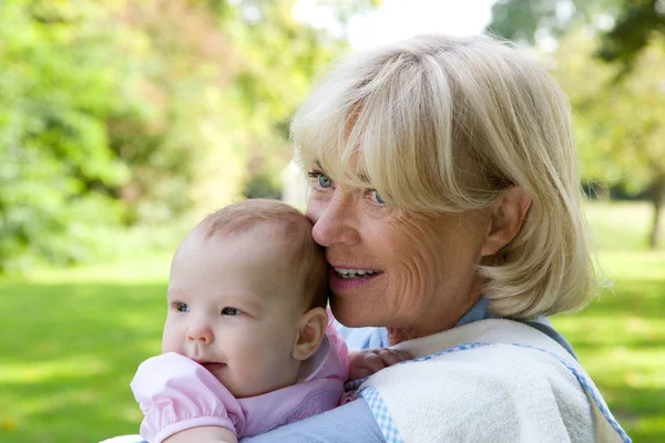 Grand-mère tenant sa petite-fille à l'extérieur — Photo