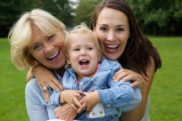 Glad mamma sondotter och barnet ler utomhus — Stockfoto