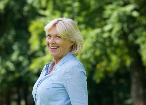 Fröhliche ältere Frau, die draußen lächelt — Stockfoto