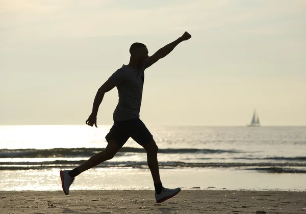 Running man with arm raised in celebration — Stock Photo, Image