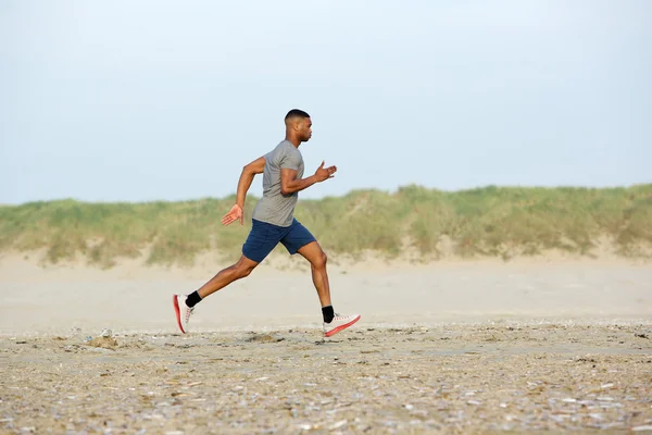 Manliga löpare tränar på stranden — Stockfoto