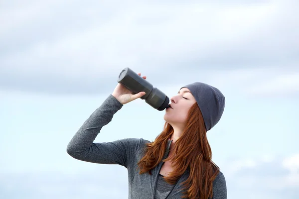 Fitness donna bere acqua dalla bottiglia all'aperto — Foto Stock