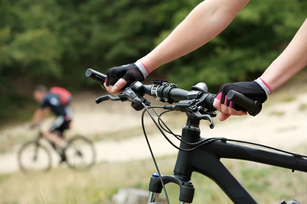 Woman hands on bicycle handle bars — Stock Photo, Image