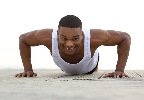 Portrait of a smiling man doing push ups — Stock Photo, Image