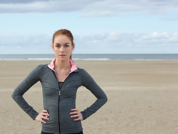 Säker sport kvinna som står vid stranden — Stockfoto