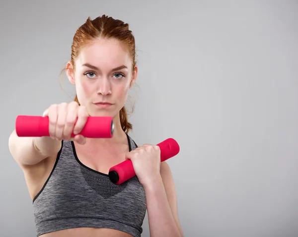Serious sports woman holding weights — Stock Photo, Image