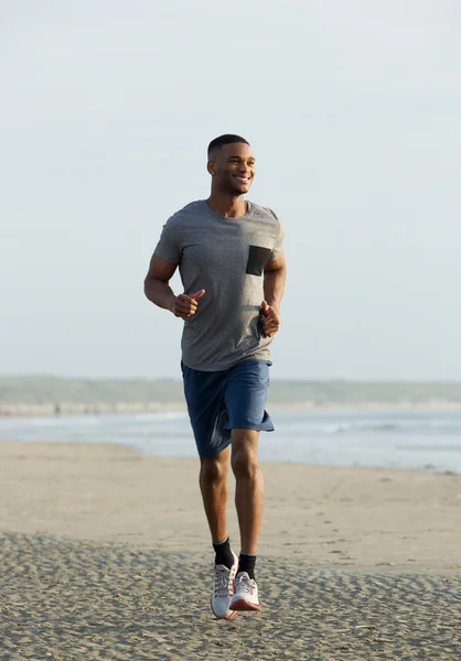 Joven afroamericano hombre sonriendo y corriendo — Foto de Stock