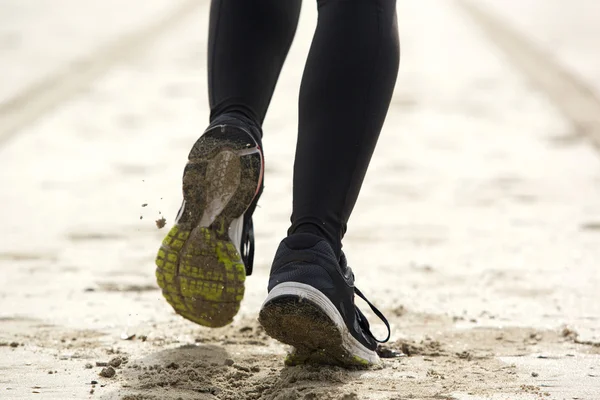 Kvinnan fötter körs på sand — Stockfoto