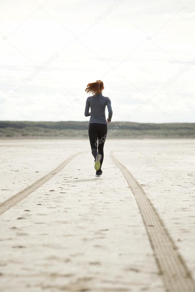 Young woman running at the beach