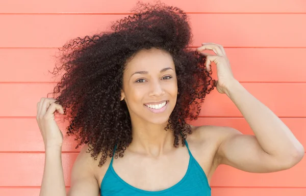 Szczęśliwy african american kobieta uśmiechając się z ręką w włosy — Zdjęcie stockowe