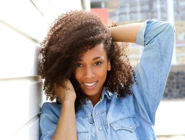 Africano mulher americana sorrindo ao ar livre com a mão no cabelo — Fotografia de Stock