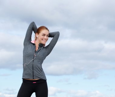 Spor kıyafeti içinde gülümseyen güzel genç kadın 