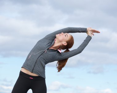 Genç kadının açık havada esneme egzersizleri yapması