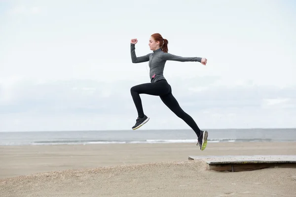 屋外ジャンプ若い女性ランナー — ストック写真