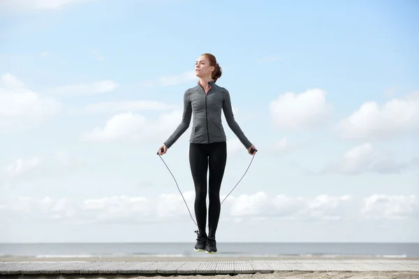 Sportiga kvinnan värmer upp med hopprep — Stockfoto