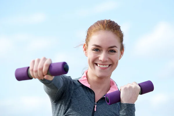 Frau lächelt mit Aerobic-Gewichten im Freien — Stockfoto