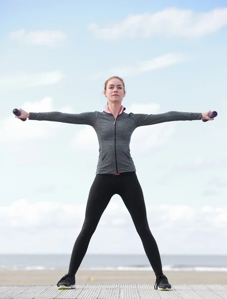 Sportliche junge Frau trainiert mit Gewichten — Stockfoto