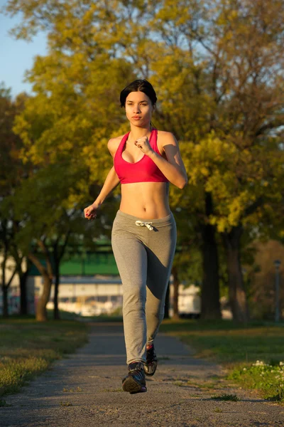 Porträt einer jungen Frau, die im Park rennt — Stockfoto