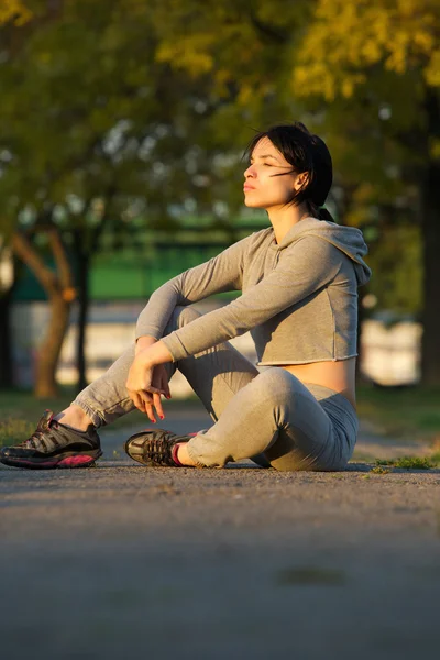 Giovane atleta donna seduta all'aperto — Foto Stock