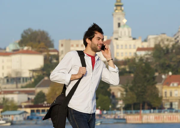 Hareket eden telefon ile açık havada yürüyen genç adam — Stok fotoğraf