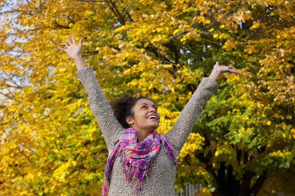 Zorgeloos jonge vrouw genieten van herfst met wapens aan de orde gesteld — Stockfoto