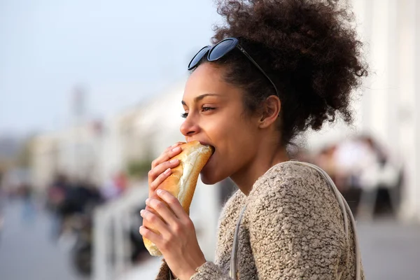 Красива молода жінка їсть бутерброд на відкритому повітрі — стокове фото