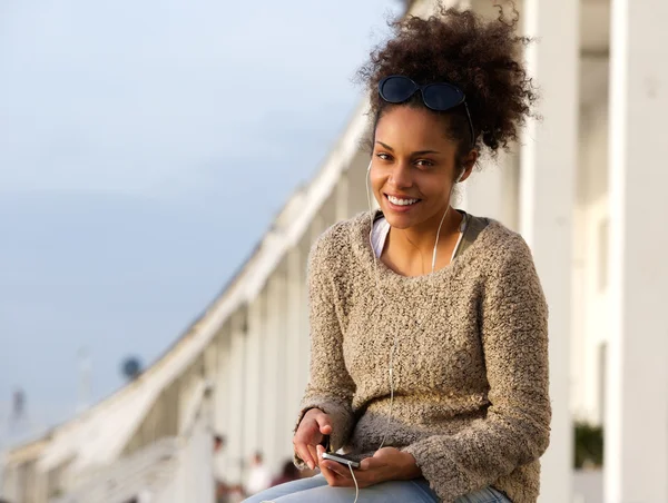 Mulher negra feliz sentado ao ar livre com telefone móvel — Fotografia de Stock