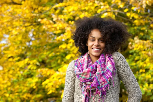 Belle jeune femme noire aux cheveux bouclés souriant à l'extérieur — Photo