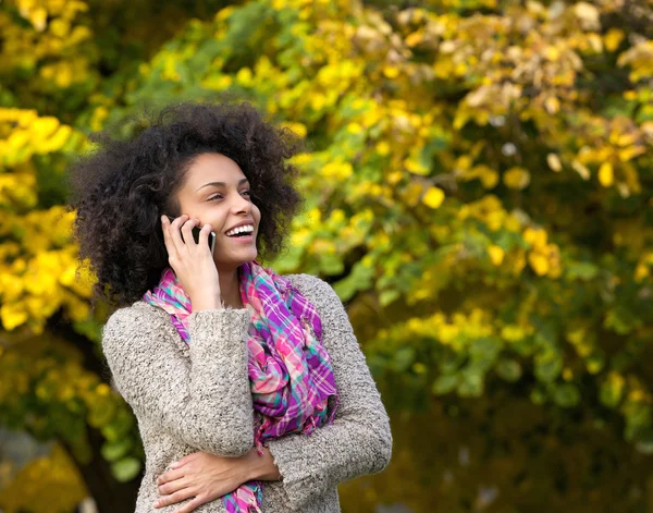 Ung kvinna skratta utomhus med mobiltelefon — Stockfoto