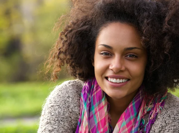 Mooie jonge Afrikaanse Amerikaanse vrouw die lacht buitenshuis — Stockfoto