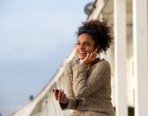 Mutlu genç kadın müzik üstünde hareket eden telefon — Stok fotoğraf