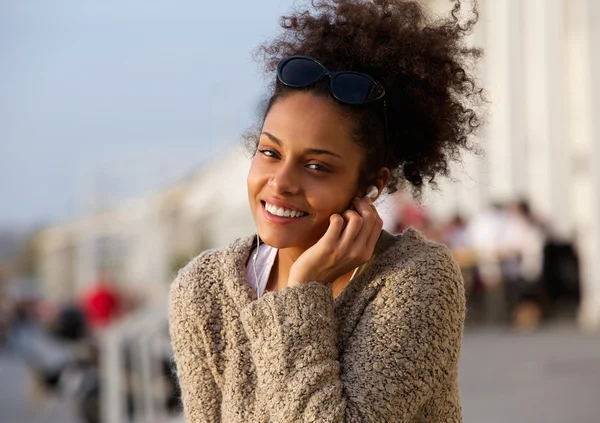 Mujer joven escuchando música en auriculares al aire libre — Foto de Stock