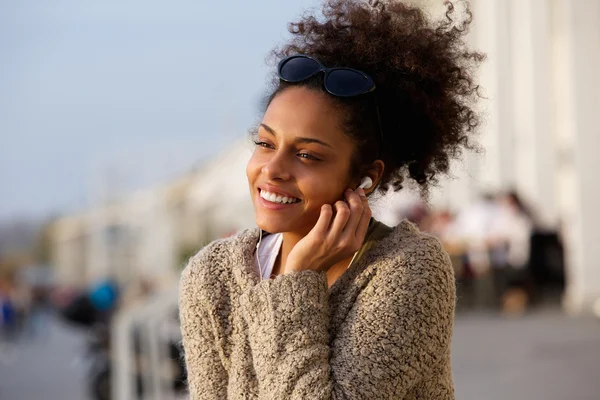 Joyeux jeune femme écoutant de la musique sur les écouteurs à l'extérieur — Photo