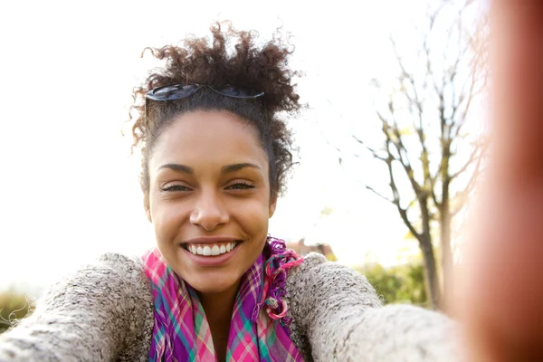 Jovem mulher sorrindo e falando uma selfie — Fotografia de Stock