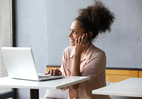 Mujer joven sonriendo y hablando en el teléfono móvil — Foto de Stock