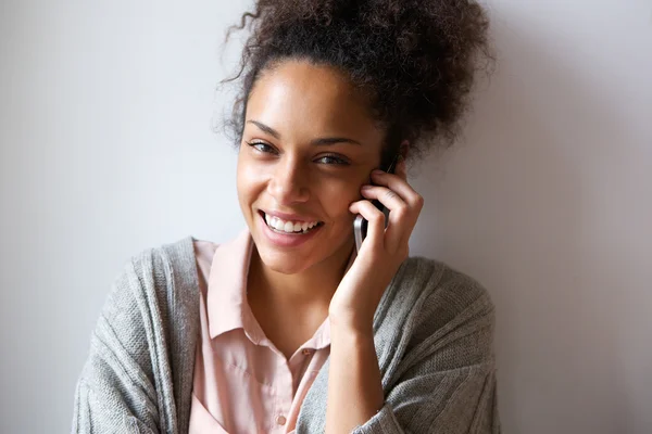 Gülümseyen ve cep telefonu üzerinde konuşurken genç kadın — Stok fotoğraf