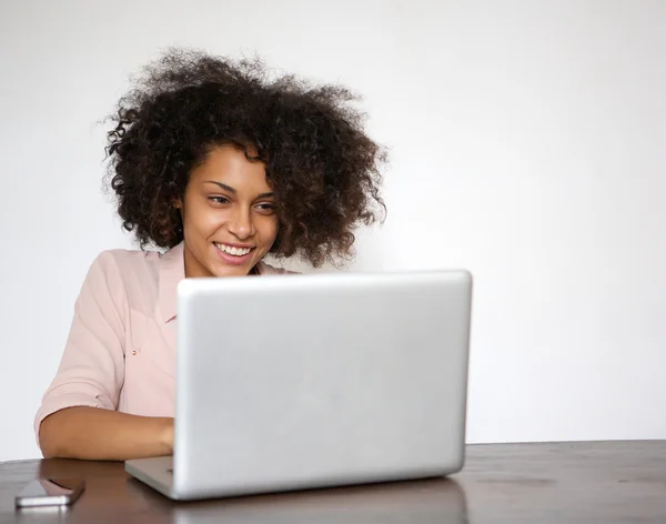 Wanita muda tersenyum dan bekerja pada laptop — Stok Foto