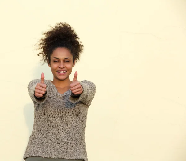 Jonge vrouw die lacht met duimen omhoog teken — Stockfoto