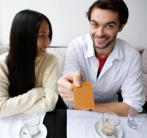 Улыбающаяся пара платит за еду в ресторане — стоковое фото