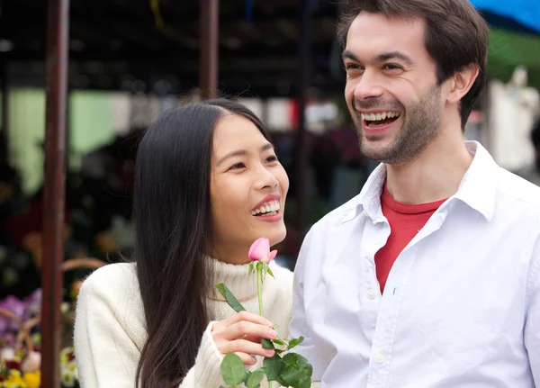 Pareja feliz sonriendo con rosa al aire libre —  Fotos de Stock