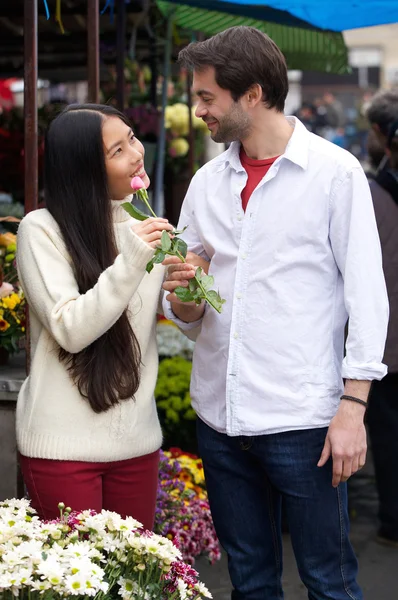 Glada unga par stående av blomsteraffär — Stockfoto