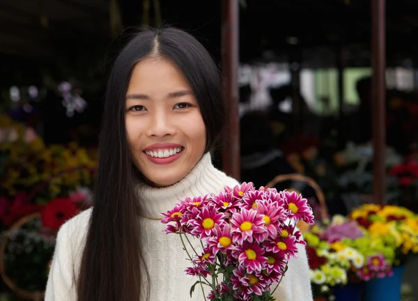 Bella donna asiatica sorridente con fiori — Foto Stock