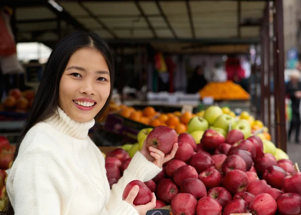 Schöne asiatische Frau lächelt und hält Äpfel in der Hand — Stockfoto