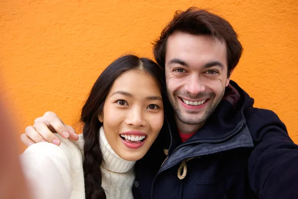 Jovem e mulher sorrindo enquanto toma uma selfie — Fotografia de Stock