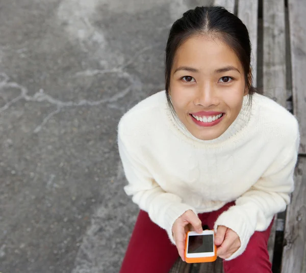 Attraktive junge Frau lächelt mit Handy — Stockfoto