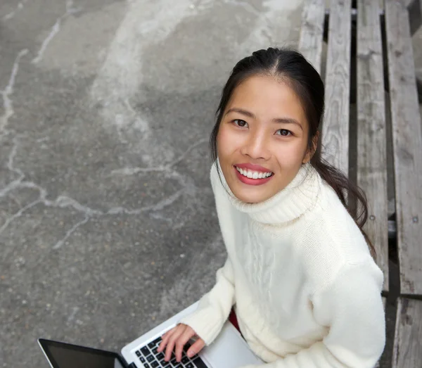 Schöne junge Frau mit Laptop im Freien — Stockfoto
