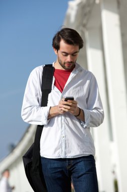Yürüyüş ve metin mesajı açık havada gönderme çanta ile genç adam