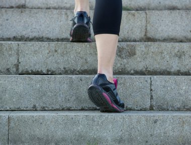 Üst kattaki spor ayakkabı içinde yürüyen genç spor kadın